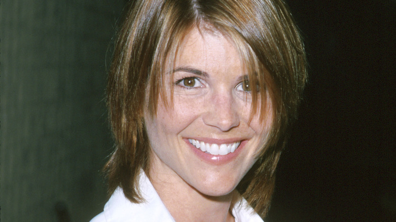 Lori Loughlin smiling in bangs and white shirt in '90s