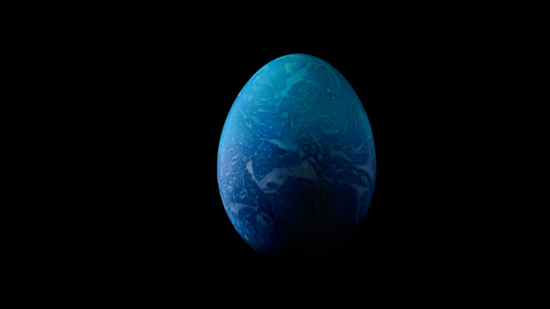 Painted egg against black background