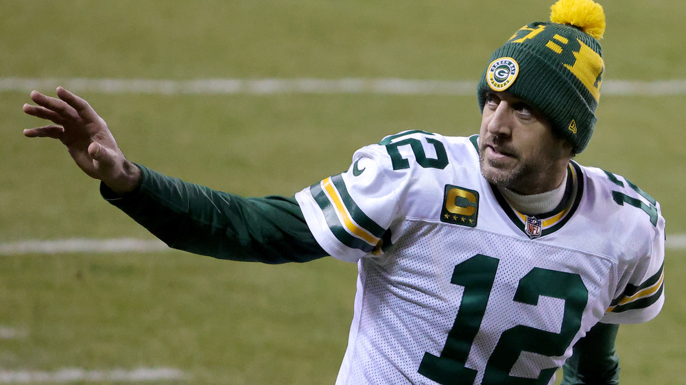 Aaron Rodgers in beanie waving