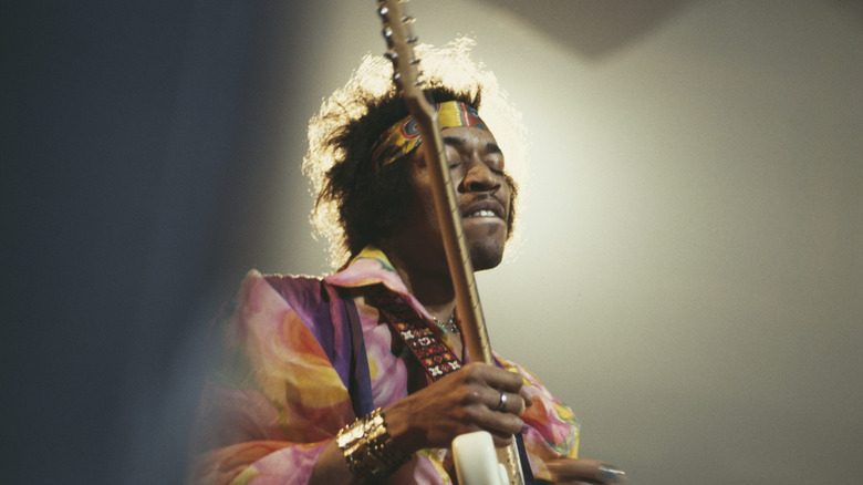 Jimi Hendrix playing guitar on stage