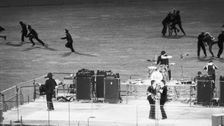 The Beatles play Candlestick Park while guards chase fans