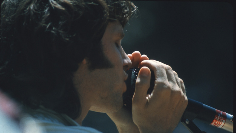 Jim Morrison holding microphone closely