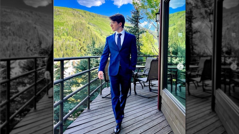 Tyler Sanders blue suit on wooden balcony