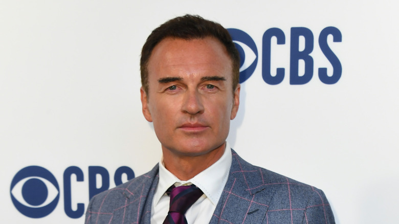 Julian McMahon squinting in a suit