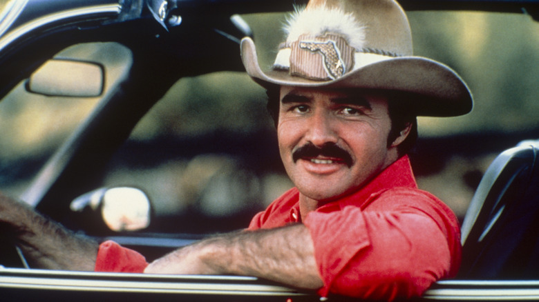 Burt Reynolds in a cowboy hat driving the Smokey and the Bandit car