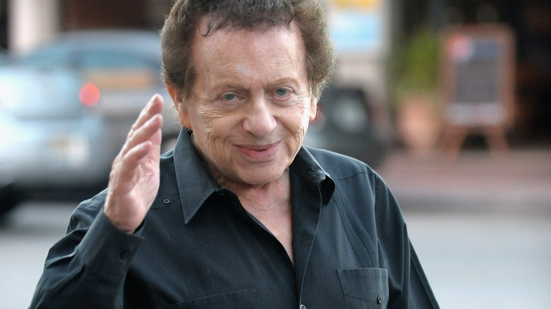 Jackie Mason waving to camera on street