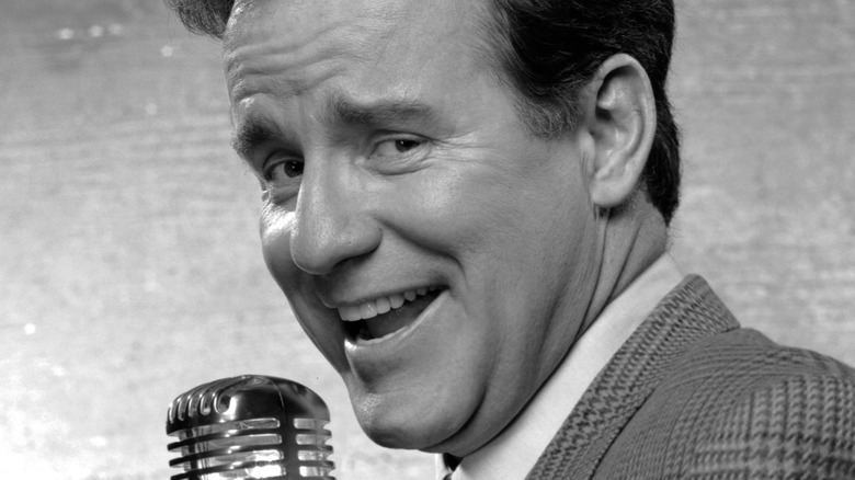 Phil Hartman talks into a microphone