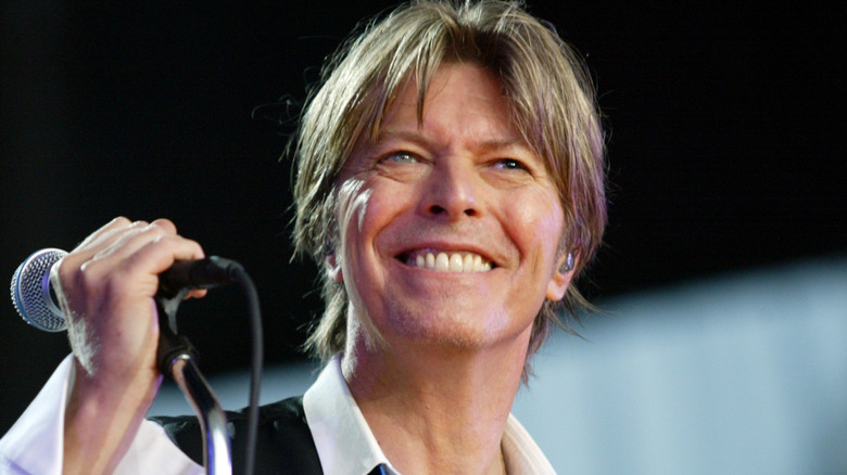 David Bowie holding a mic and smiling