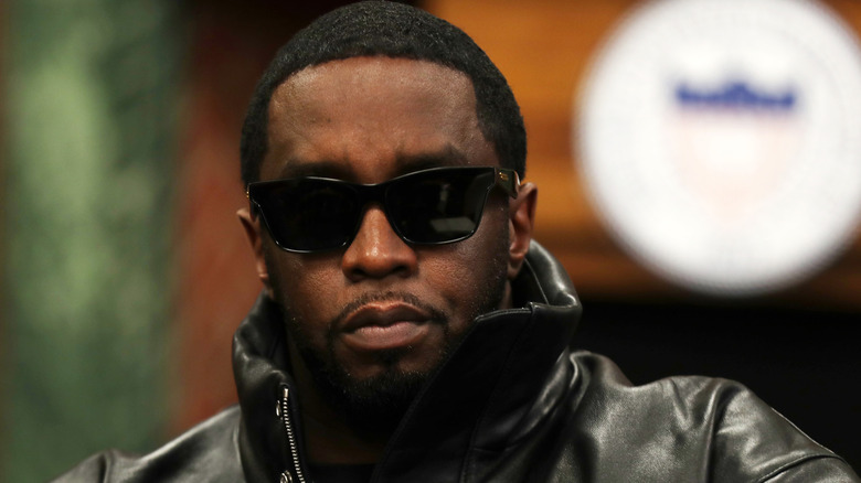Sean Diddy Combs pointing in grey suit