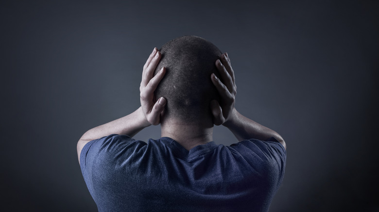 teenage boy hands covering ears