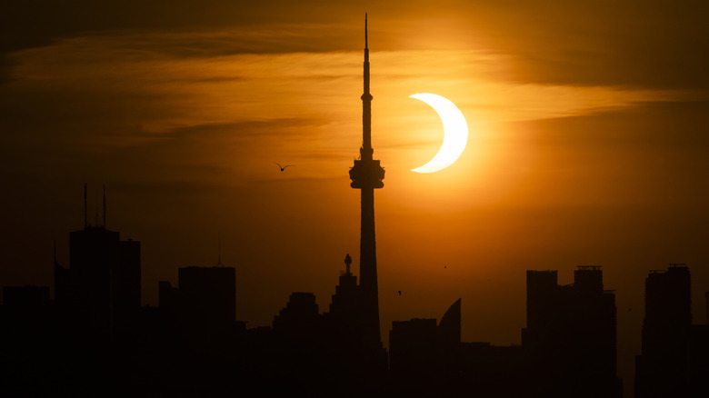 Solar eclipse behind the Toronto skyline.
