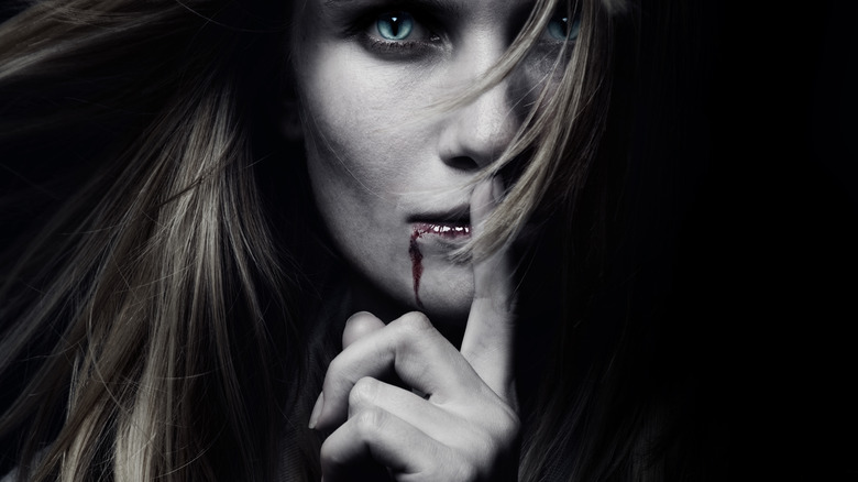 Vampire finger pressed to bloody lips