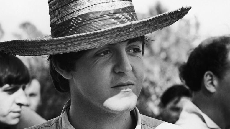 Paul McCartney wearing wide-brimmed straw hat while filming Help!