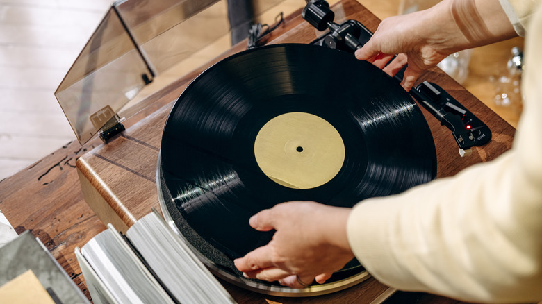 Woman placing vinyl on record player
