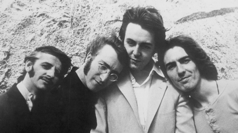 The Beatles posing against a rock wall circa 1967