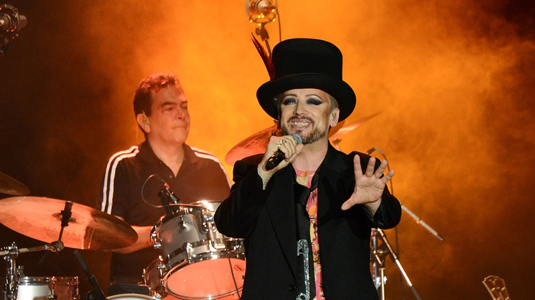 Jon Moss playing drums and Boy George singing on stage