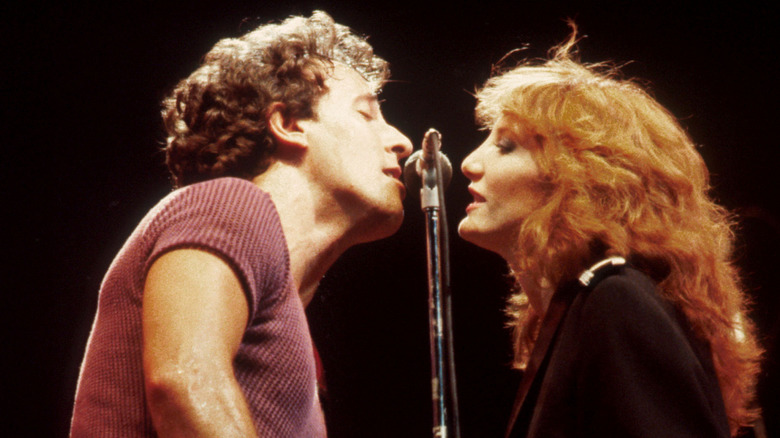 Bruce Springsteen and Patti Scialfa singing into same microphone onstage