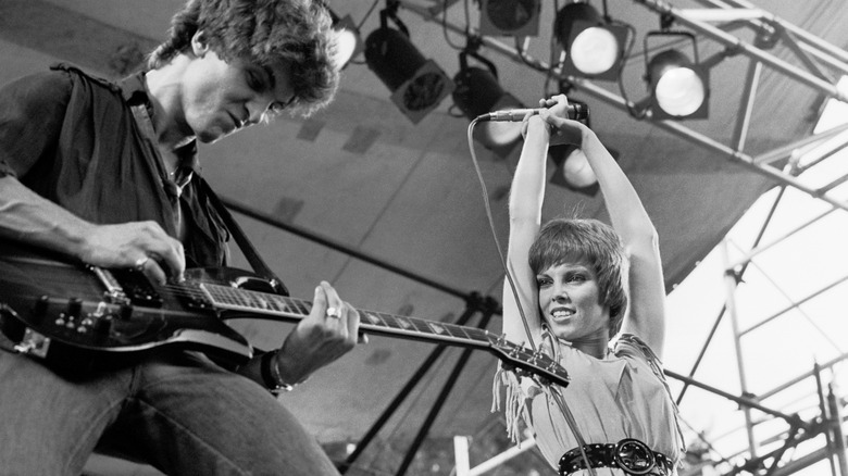 Neil Giraldo and Pat Benatar performing on stage