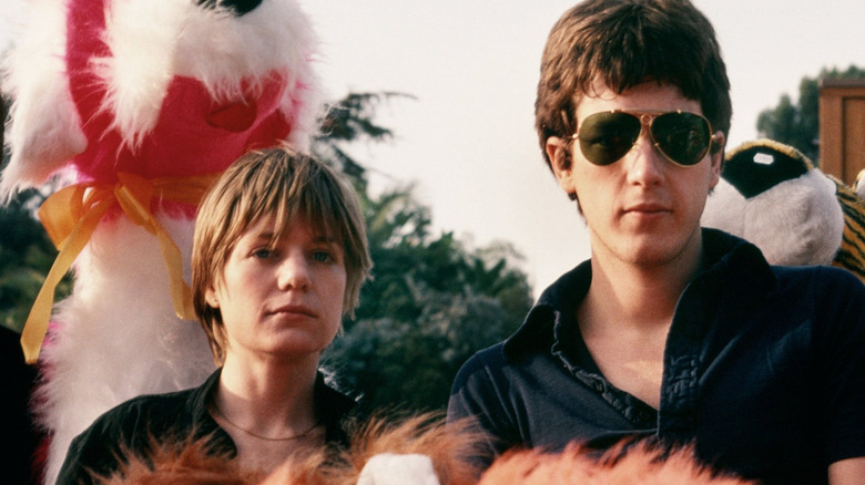 Tina Weymouth and Chris Frantz staring at camera with stuffed animals