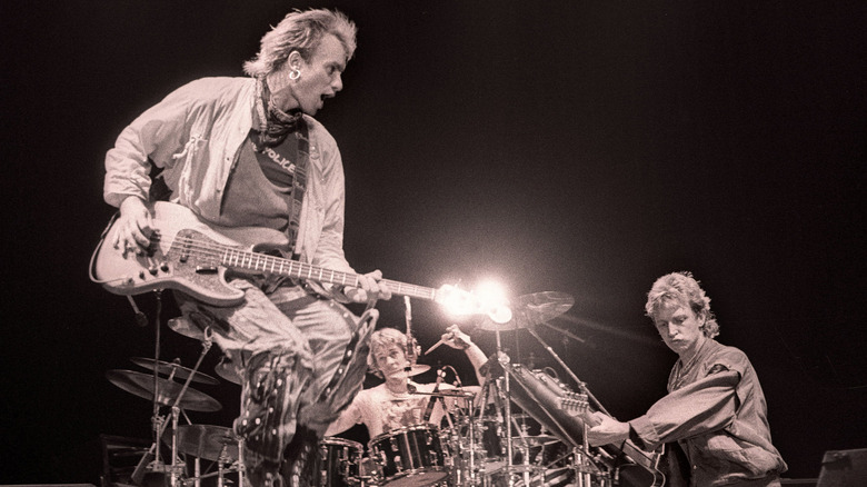 Sting jumping with guitar as the Police perform on stage