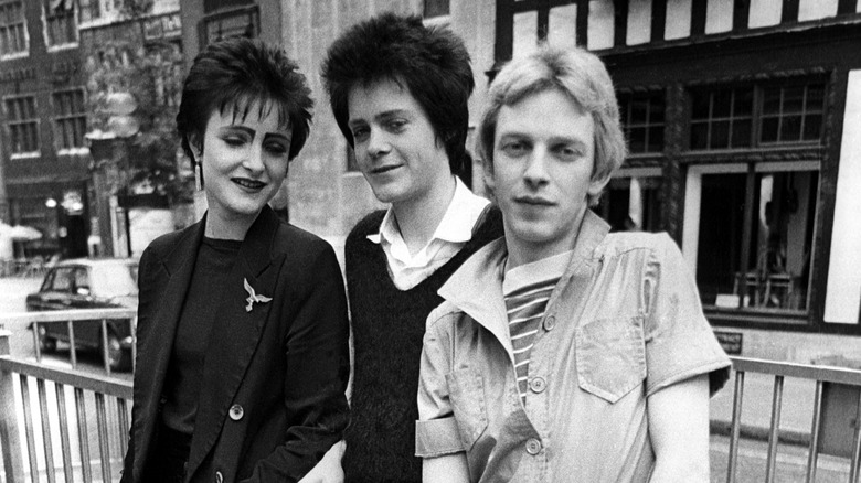The band Siouxsie and the Banshees posing on a city street.