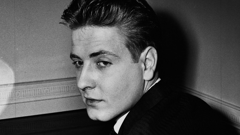Eddie Cochran brooding in the corner of a room, black and white photo