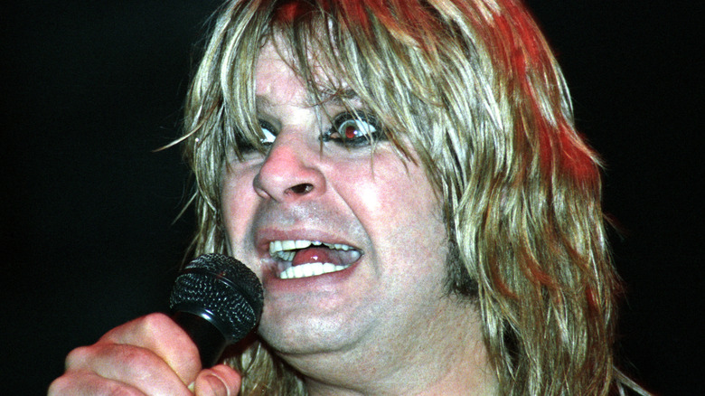 ozzy osbourne looking crazed while performing, holding a microphone