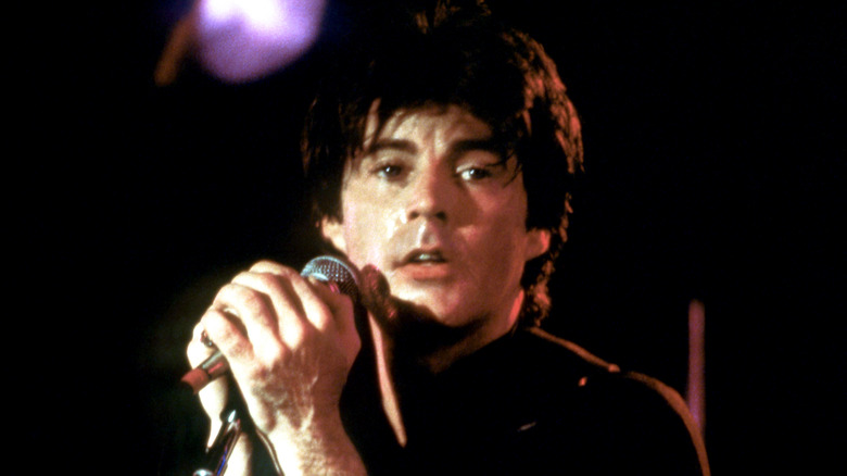 Rick Nelson holding a microphone and looking off into the distance