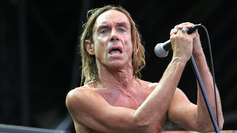 Iggy Pop shirtless holding mic on stage
