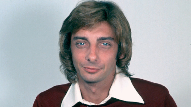 Barry Manilow smirking in a sweater