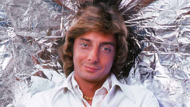Barry Manilow smirking against a wall of foil in 1976