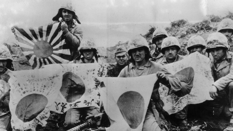 Marines holding Japanese flags