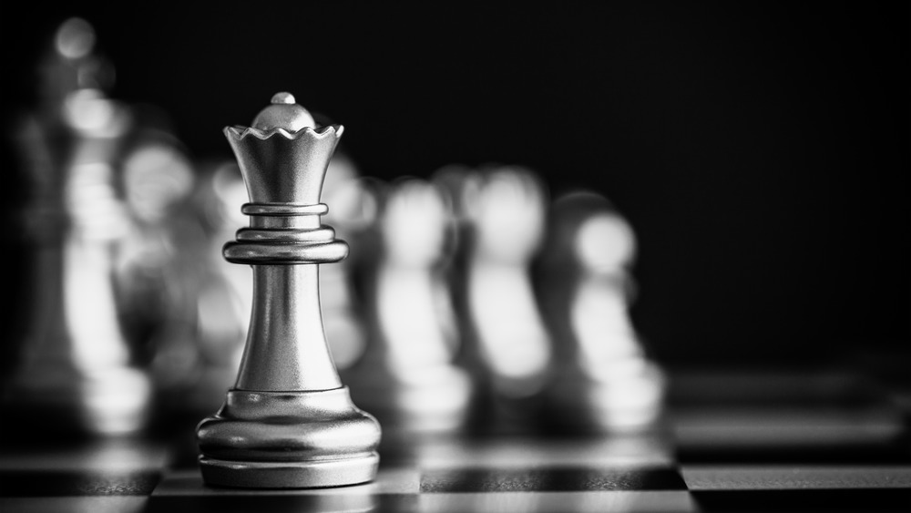 Chess queen piece on chess board