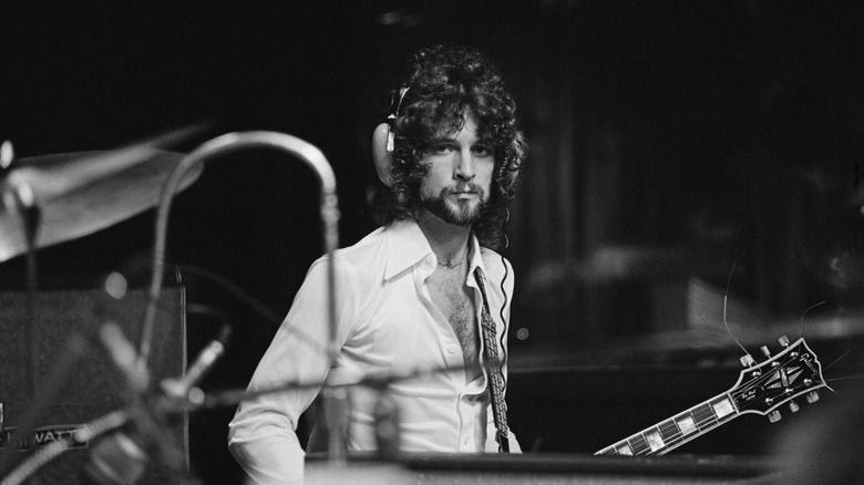 Lindsey Buckingham in recording studio with headphones and guitar