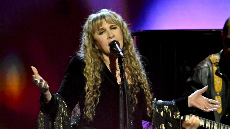 Stevie Nicks singing live in front of microphone with hands out