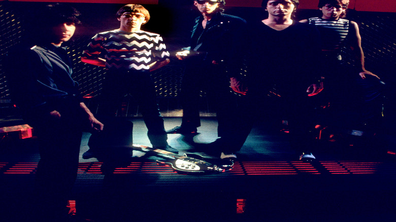 The Cars posing on a darkened stage
