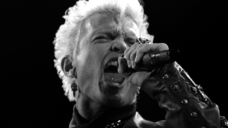 Billy Idol on stage singing into microphone leather jacket