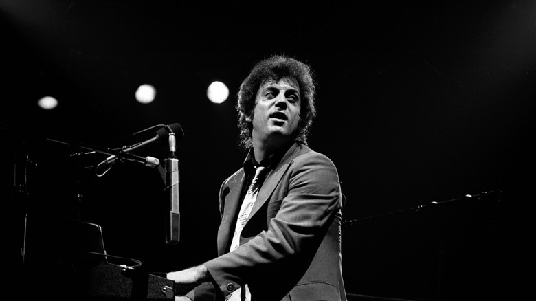 Billy Joel at piano turned and looking backward