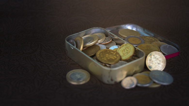 Old metal box with coins from different countries