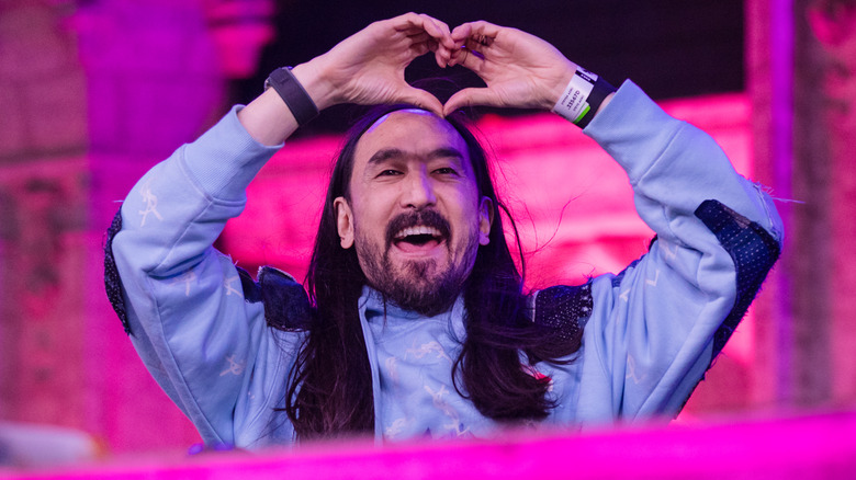 DJ Steve Aoki making a heart gesture on stage at Tomorrowland Brasil 2024