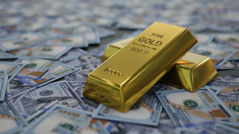 gold bars resting on bed of US currency