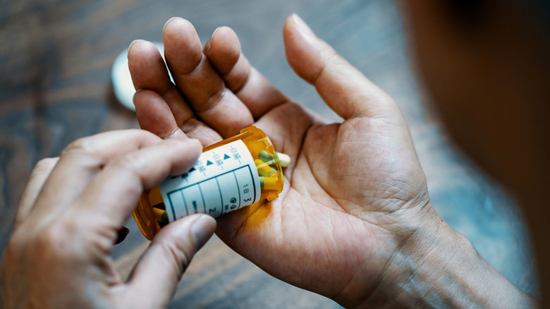 man pouring pills into hand