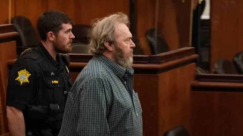 smith enters bond hearing with court officer