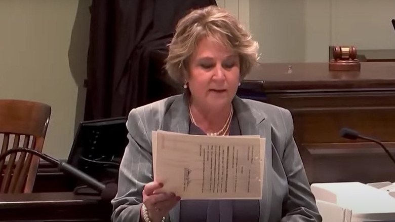 screenshot of becky hill in court holding papers and speaking