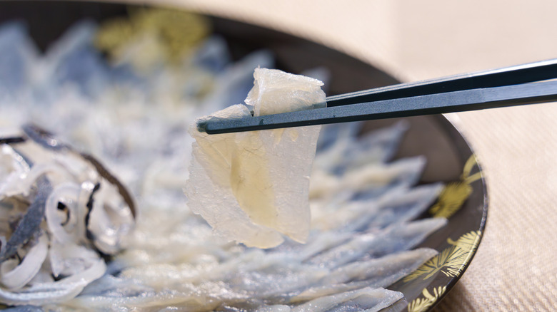 sample of fugu sashimi in bowl with chopsticks