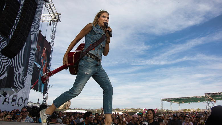 Sheryl Crow striding across stage