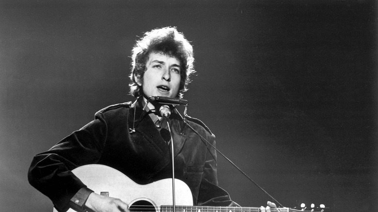 Bob Dylan playing guitar and singing