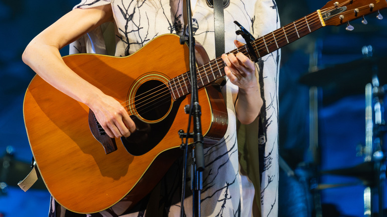PJ Harvey playing guitar on stage