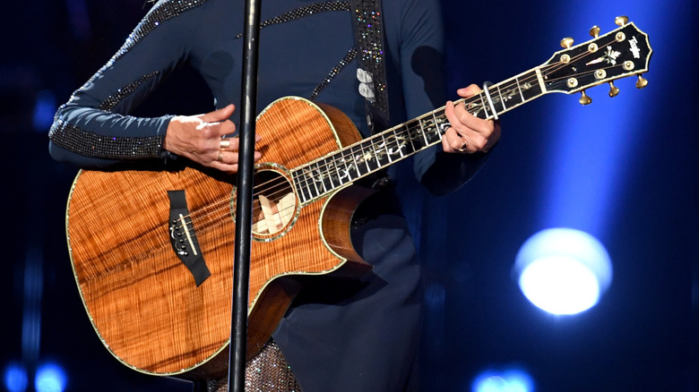 Faith Hill performing on stage with her guitar.