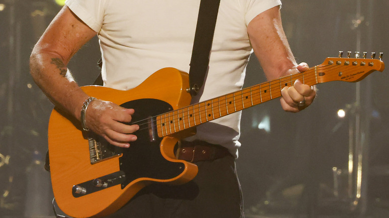 John Mellencamp playing on stage.